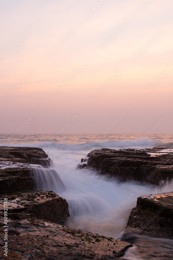 Fototapeta premium Morning wave coming through between rocks.