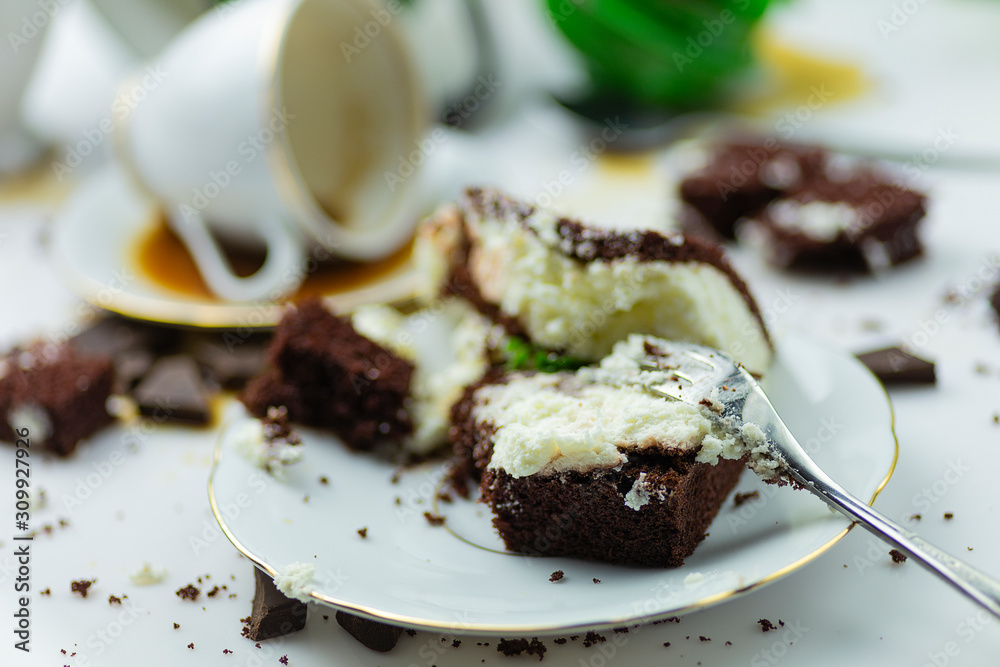 A mess on a table with cake in the background.