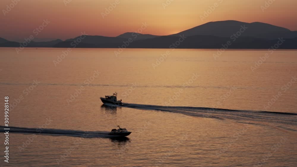 Barcos Cruzando el horizonte en la puesta del sol en la isla hydra Barcos Cruzando el horizonte en la puesta del sol en la isla hydra
