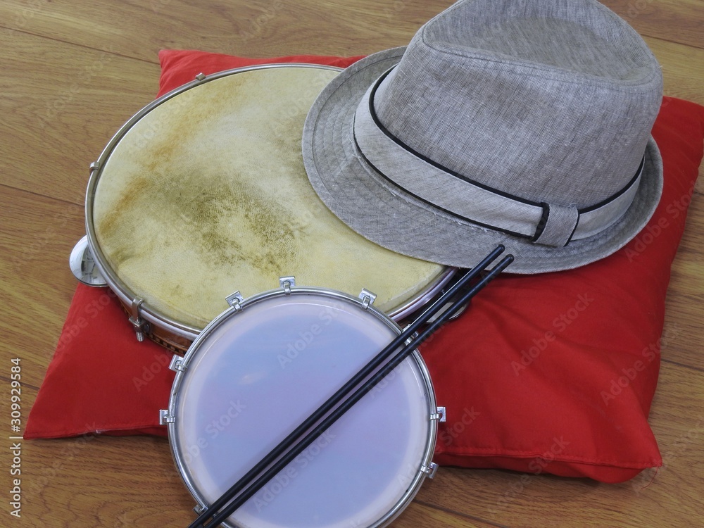 Fototapeta premium Close-up of a samba player (sambista) hat and two Brazilian percussion musical instruments: “tamborim” with drumstick and 
