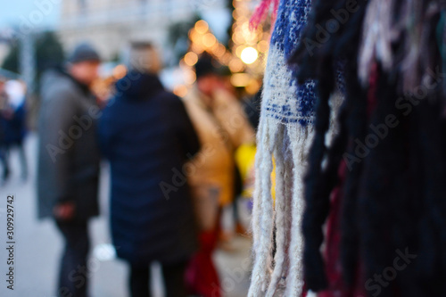 Partially blurred photo of a traditional Christmas fair with scarves and lights
