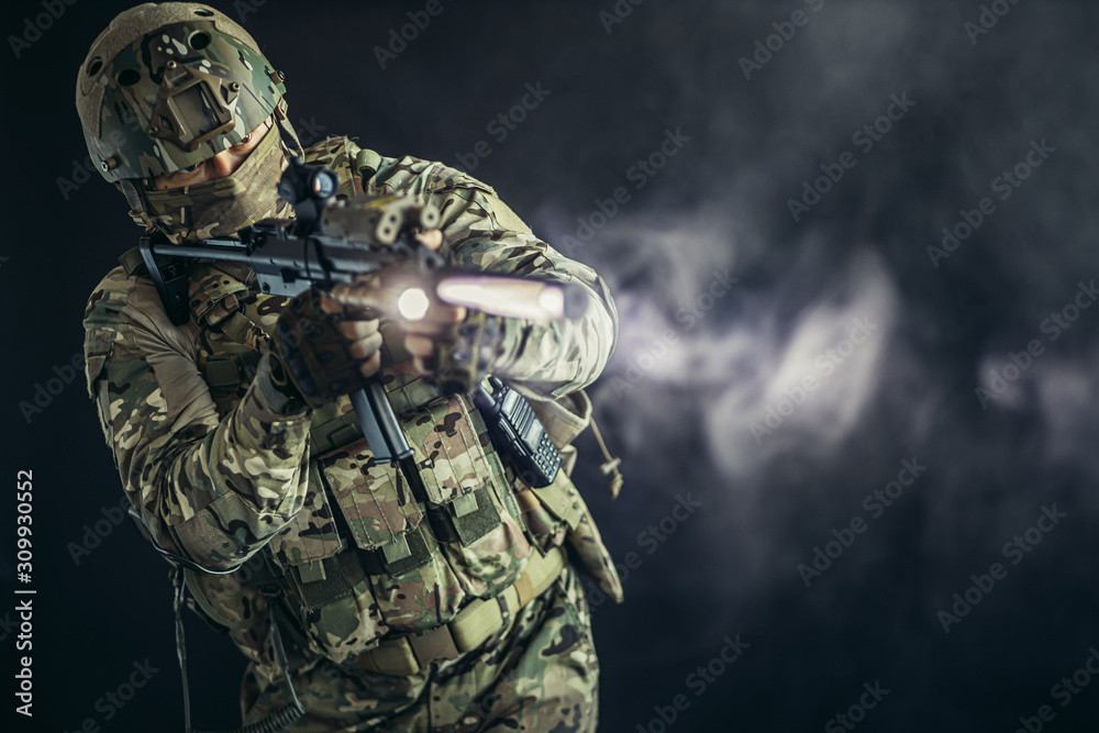 young man from military forces in green military wear try to shoot on rifle gun through smoke fogger young man from military forces in green military wear try to shoot on rifle gun through smoke fogger