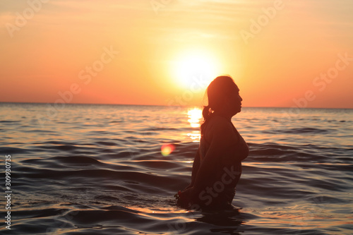 silhouette of woman on the beach at sunset © cdcd