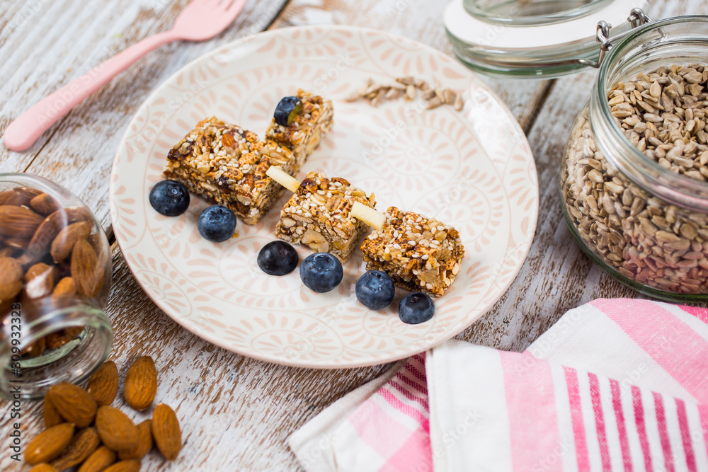 Fototapeta premium Fun food for kids. Homemade healthy cookies made with sunflower seeds, sesame seeds, dry fruits and honey with berries