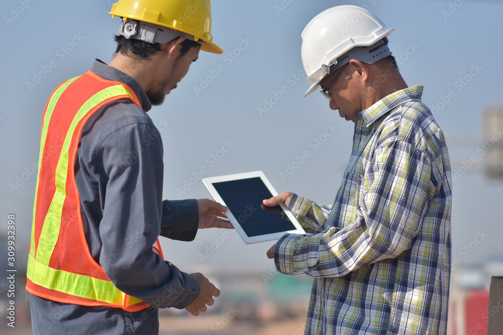 Two Engineering using tablet technology checking inspection work construction and talking planing project management Two Engineering using tablet technology checking inspection work construction and talking planing project management
