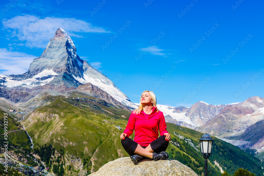 women meditating on high mountain in sunset background