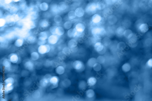 Modern beautiful holographic background of holiday lights bokeh in trendy blue color. Trendy blue backdrop for your design. Color of the year 2020 concept. Wallpaper design.