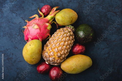 Fototapeta Naklejka Na Ścianę i Meble -  Assortment fresh exotic tropical fruits on dark blue background. Flat lay