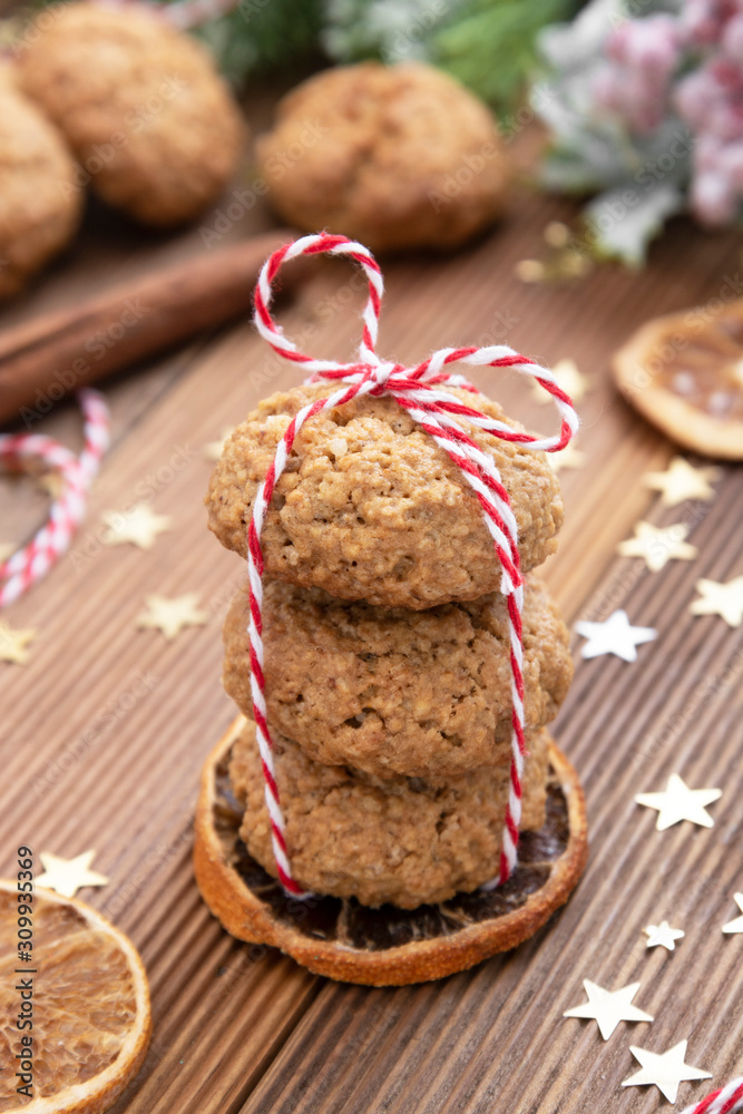 Fototapeta premium Stack of homemade oatmeal cookies. Christmas healthy cookies, biscuits. Rustic wooden table. Winter decoration.