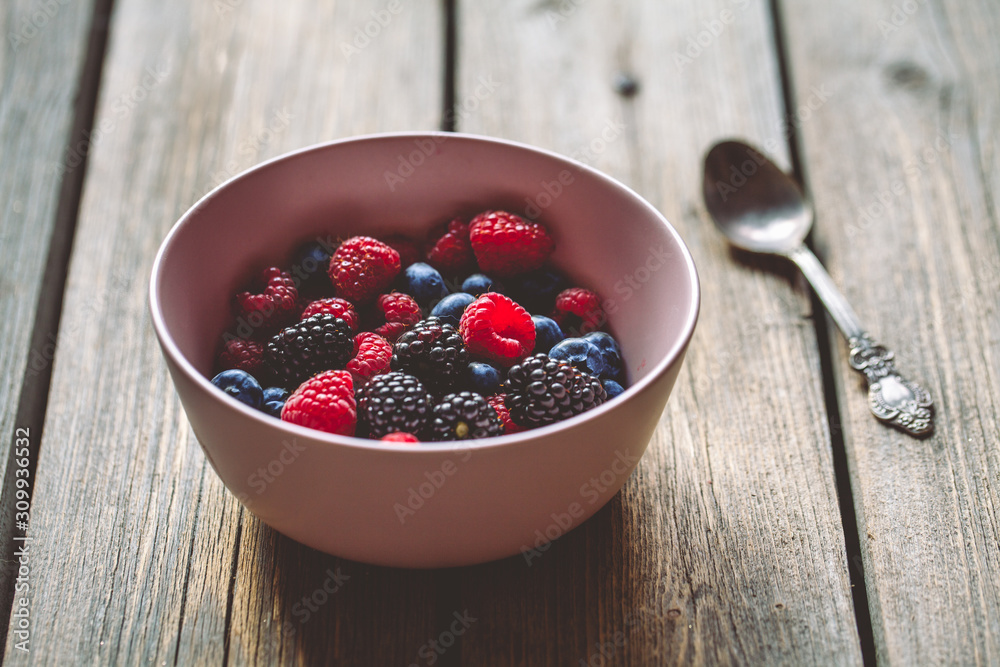 summer berries raspberries and blackberries, blueberries in a plate on a wooden background summer berries raspberries and blackberries, blueberries in a plate on a wooden background