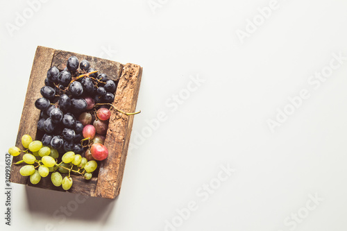 Wooden box with red grapes isolated on white background.