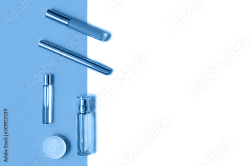 Flat lay composition with decorative makeup products and parfume on trendy blue and isolated white background. Makeup and beaty concept. Mockup for your design. Color of the year 2020 concept. Copy