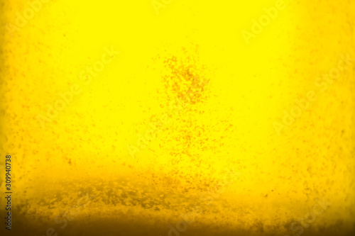 yellow liquid honey texture close up with some solid particles in transparent jar
