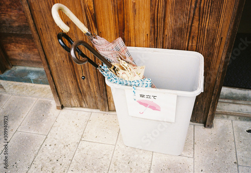 An umbrella in the rainy season that is placed in front of the house door