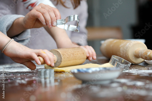 Kinder Hände backen Weihnachtsplätzchen, mit Teig, Zutaten, Mehl, Nudelholz und Backform. photo