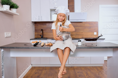 Fotografie diligent and sedulous little girl cook and bake independently, make food at home without adults