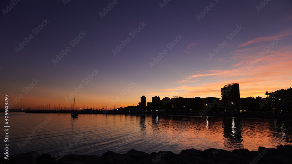 Fototapeta premium Ciudad con mar en puesta de sol