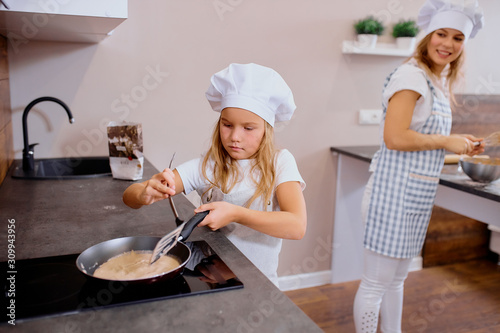 Vászonkép diligent and sedulous little girl cook and bake independently, make food at home without adults