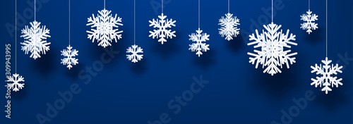 Winter horizontal blue background with white paper kirigami snowflakes.