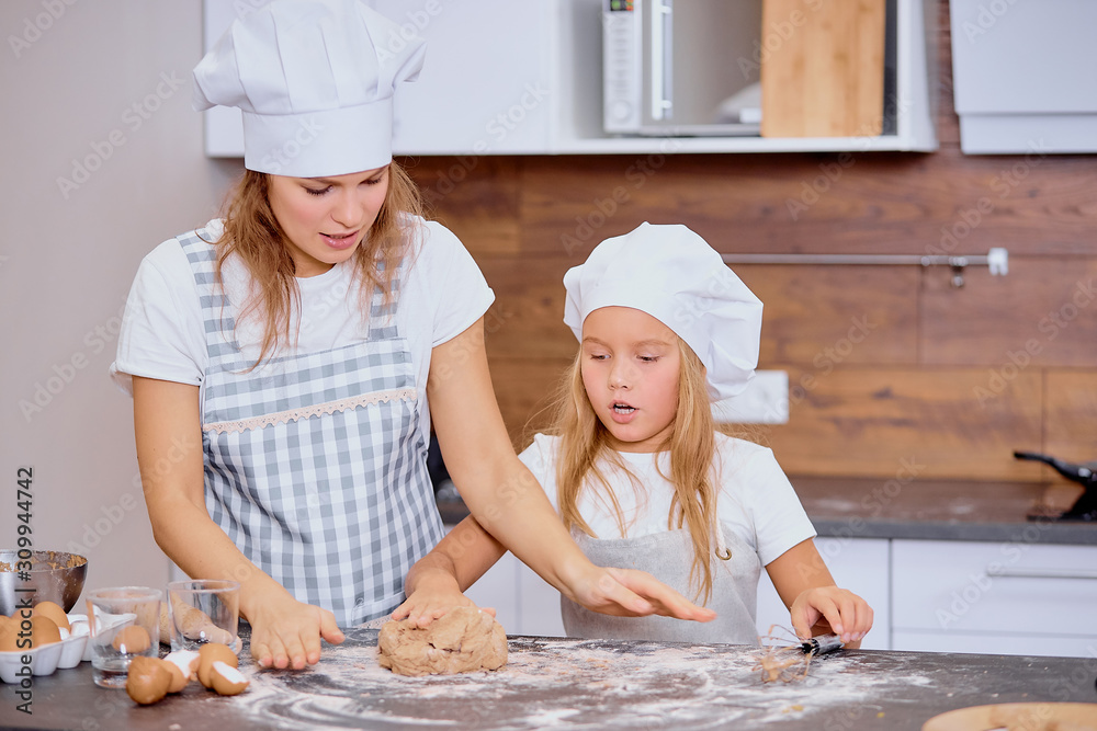 making tasty delicious cake by little girl and caucasian woman, baking together at home making tasty delicious cake by little girl and caucasian woman, baking together at home
