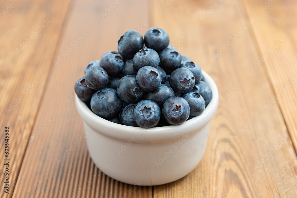 Ripe blueberries in the bowl on the wooden table. Fresh berries for breakfast. Ripe blueberries in the bowl on the wooden table. Fresh berries for breakfast.