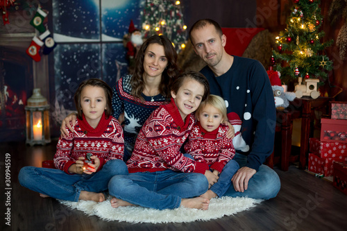 Happy smiling family, mom, dad and three boys, having family portrait at home for Christmas © Tomsickova