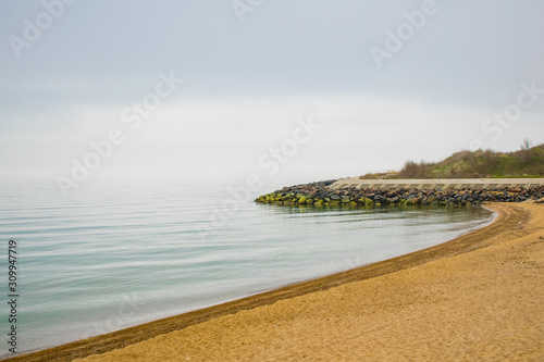 Beach line with a breakwater made of concrete and granite stones revetment.  