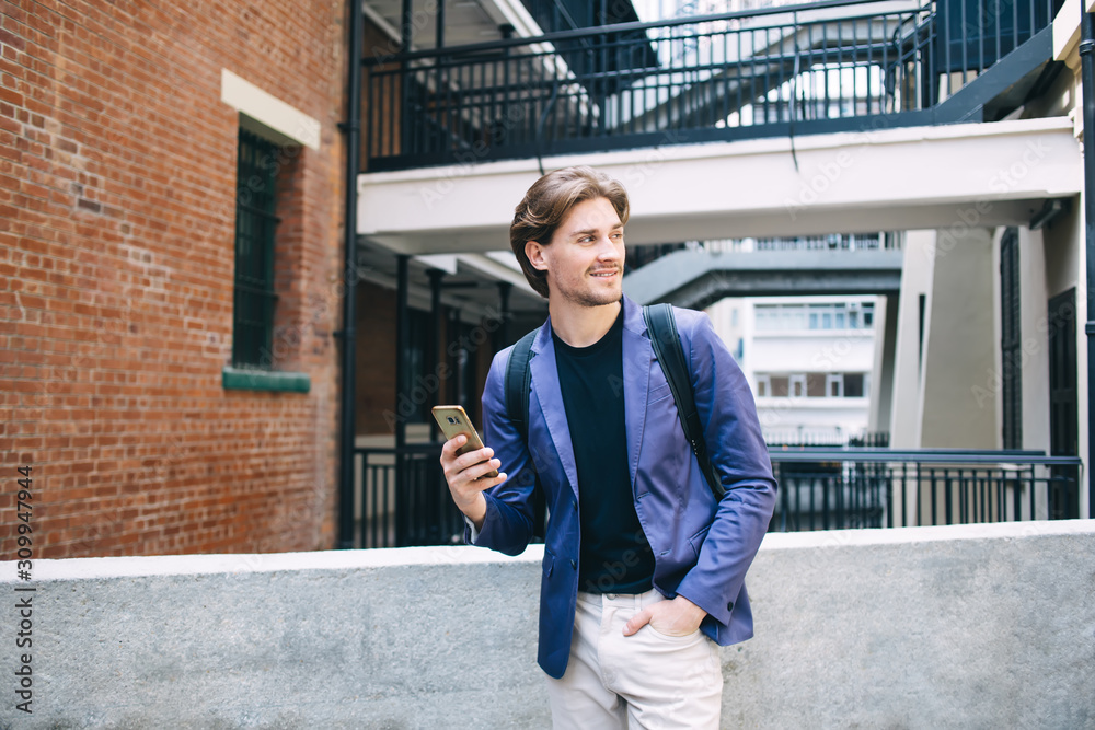 Confident male with smartphone outside building Confident male with smartphone outside building