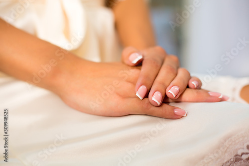 beautiful women's hands with French manicure on the background of lingerie