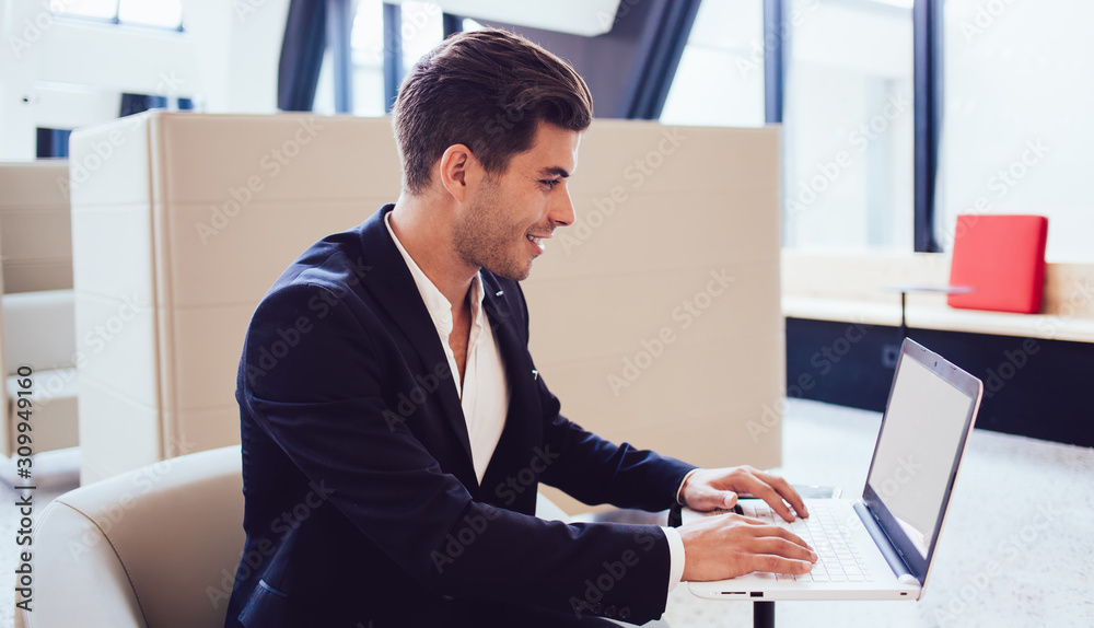 Laughing employee working with laptop in office Laughing employee working with laptop in office