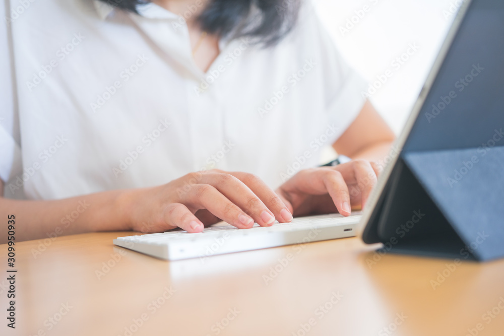 Young Freelancer or Businessman working at home office and typing on keyboard smartphone tablet. Working Online Or Studying And Learning While Using smartphone tablet. Freelance Work, Business concept Young Freelancer or Businessman working at home office and typing on keyboard smartphone tablet. Working Online Or Studying And Learning While Using smartphone tablet. Freelance Work, Business concept