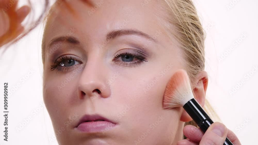 Woman face painting. Makeup artist applying blush bronzer with brush to model cheek. Cosmetic beauty procedures and makeover concept. Slow motion Woman face painting. Makeup artist applying blush bronzer with brush to model cheek. Cosmetic beauty procedures and makeover concept. Slow motion