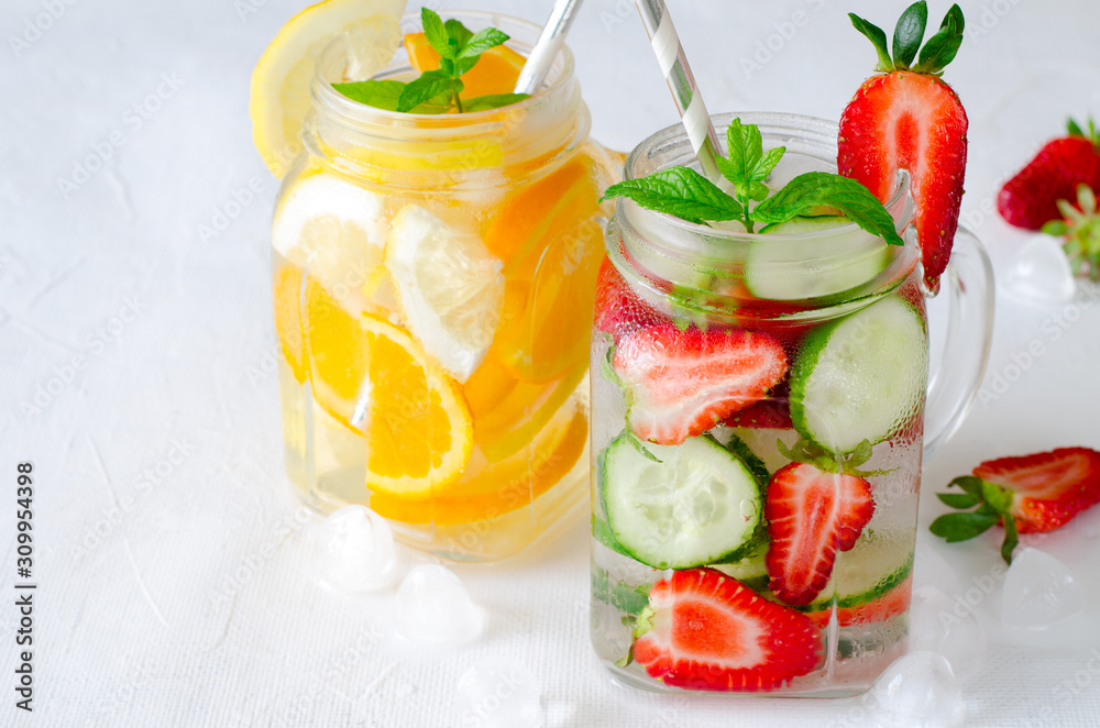 Summer refreshing iced drinks with orange, lemon, cucumber and strawberry on white background Summer refreshing iced drinks with orange, lemon, cucumber and strawberry on white background