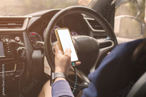 Asian women are using smart phones while driving with white screen and clipping path. Women use mobile phones on cars.Dangers of using the phone while driving concept.