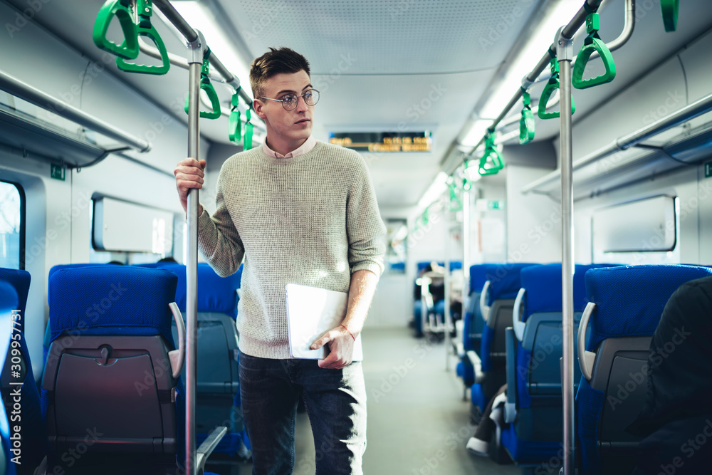 Thoughtful man with laptop riding in train Thoughtful man with laptop riding in train