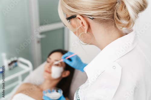 Photo of attractive caucasian woman getting cosmetic procedure