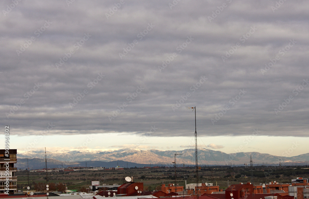  Cloudy winter day with snowy mountains on the horizon