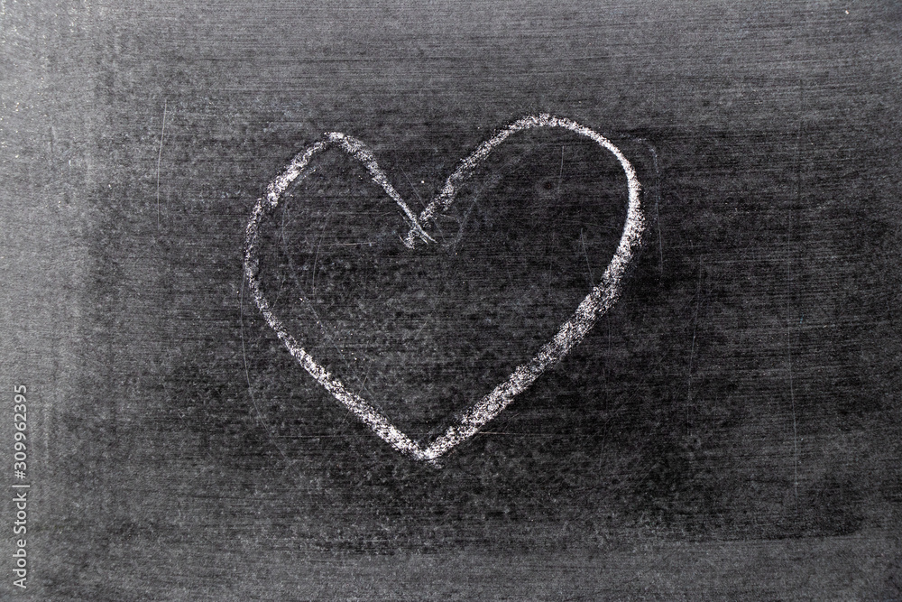 White color chalk hand drawing in heart shape on blackboard background White color chalk hand drawing in heart shape on blackboard background
