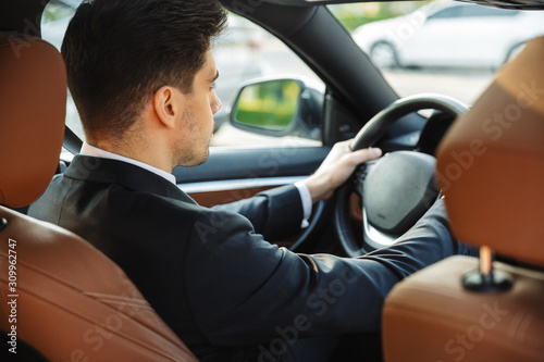 Photo of focused young businessman looking forward while driving car © Drobot Dean