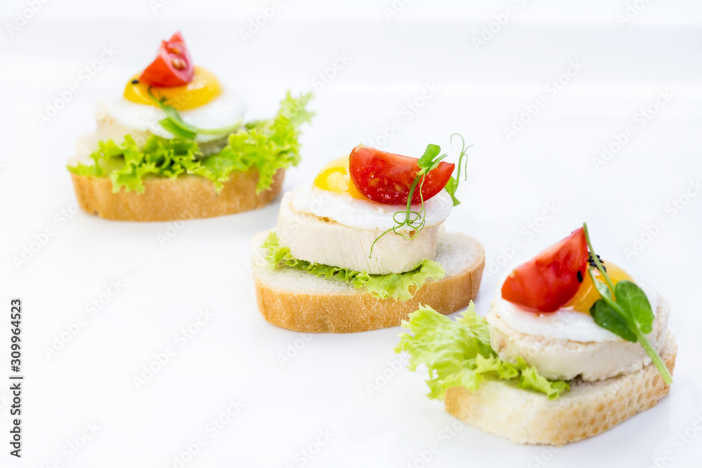 Snacks and canapes on the banquet table, closeup shot on a white background.