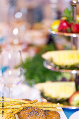Blurred background of a banquet table with buns in the foreground.