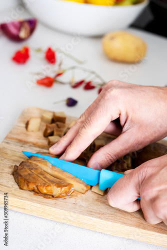 man cutting a piece of seitan