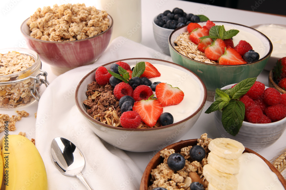 Tasty homemade granola served on table. Healthy breakfast with a bowl of oatmeal with banana, blueberries, strawberries and healthy food for Breakfast Tasty homemade granola served on table. Healthy breakfast with a bowl of oatmeal with banana, blueberries, strawberries and healthy food for Breakfast