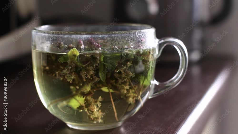 transparent mug with hot herbal mint tea in a kitchen transparent mug with hot herbal mint tea in a kitchen