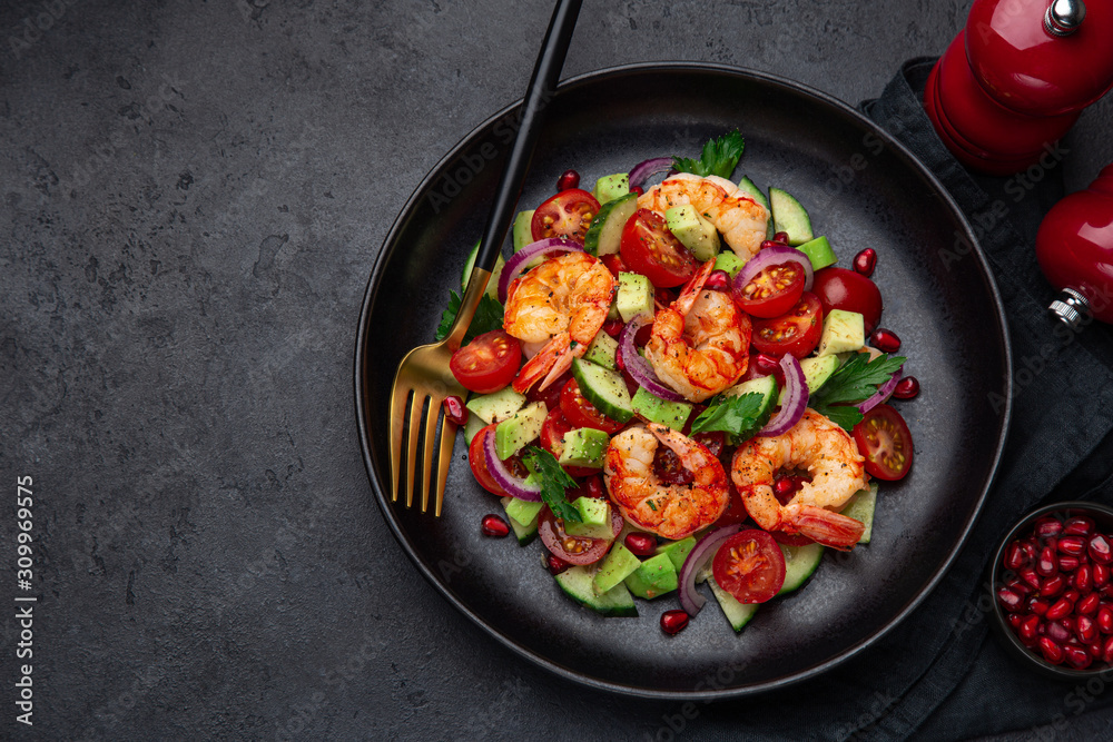 grilled shrimps and vegetable  salad on black plate