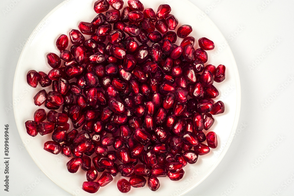 pomegranate seeds in bowl isolated on white background