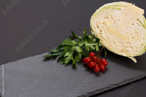 Fresh cabbage with herbs and spices on the black background
