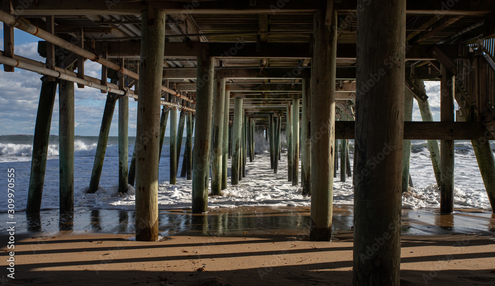 Rough Surf under wooden pier at beach Rough Surf under wooden pier at beach
