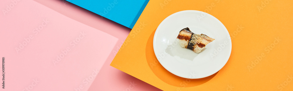 fresh nigiri with eel on plate on blue, pink, orange surface, panoramic shot fresh nigiri with eel on plate on blue, pink, orange surface, panoramic shot