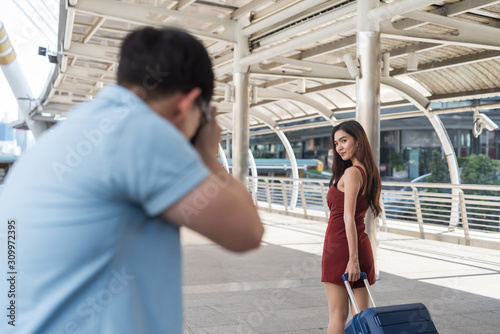 woman with luggage take photo by boyfriend